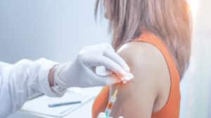 doctor injecting vaccination for young women.