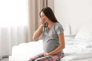 Young pregnant woman suffering from toxicosis at home