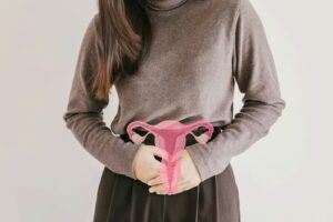 Woman holding hands over uterus part of her abdomen